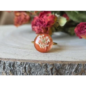 Anillo pequeño coral con gerbera y amimaju encapsuladas en resina sobre base dorada