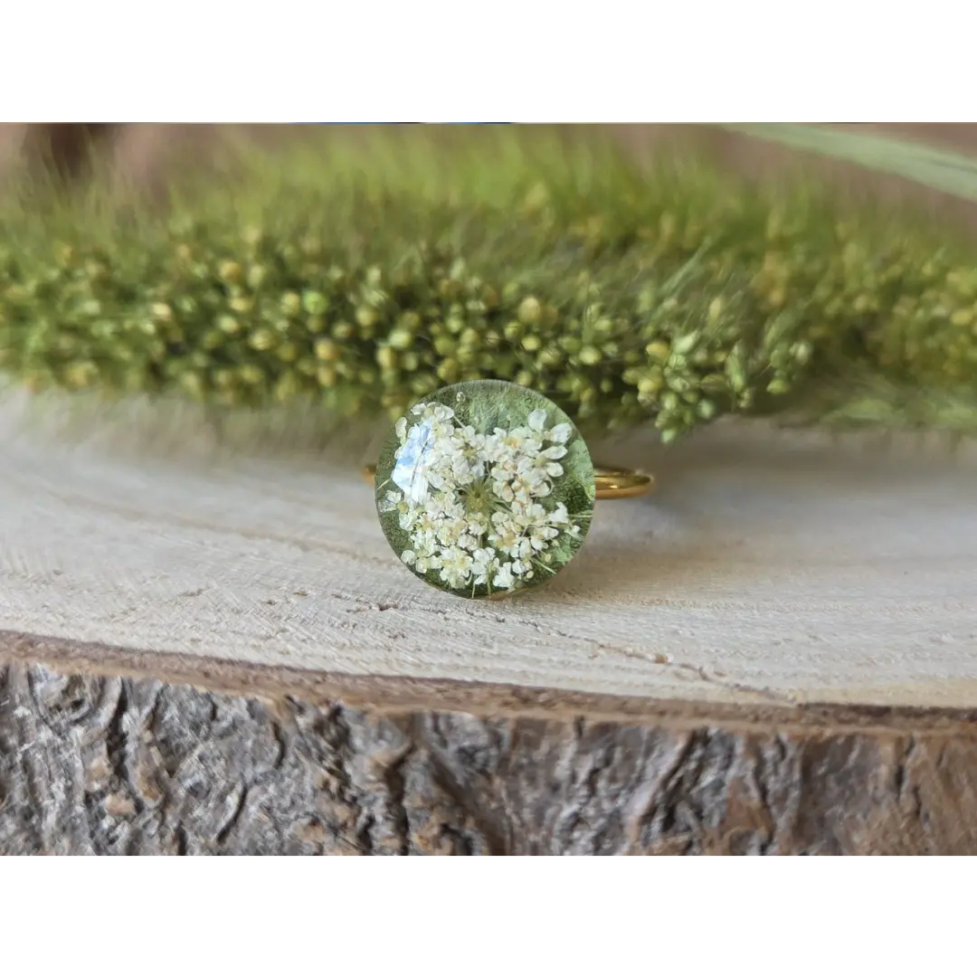 Anillo pequeño verde con hoja de rosa y flores de amimaju encapsuladas en resina