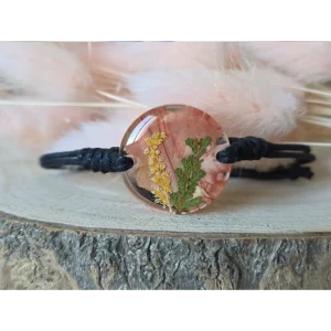 Pulsera coral con clavel, brezo y astilbe japónica encapsulados en resina con fondo de plumas suaves